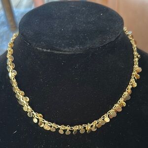 Gold tone paperclip chain with mini coin embellishment.
